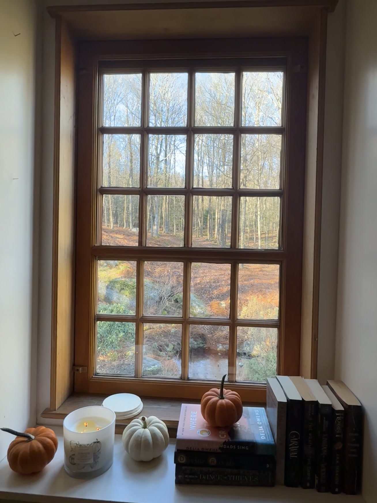 Autumn window seat with pumpkins, candle and books